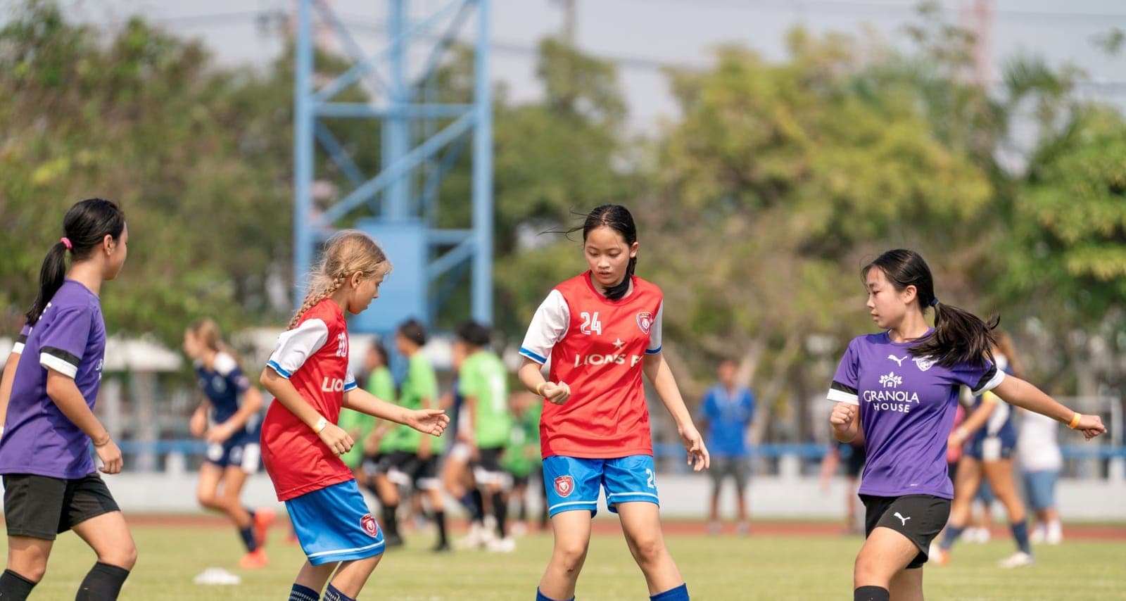 Two Lions FC players working the ball through a match, opponents either side of them