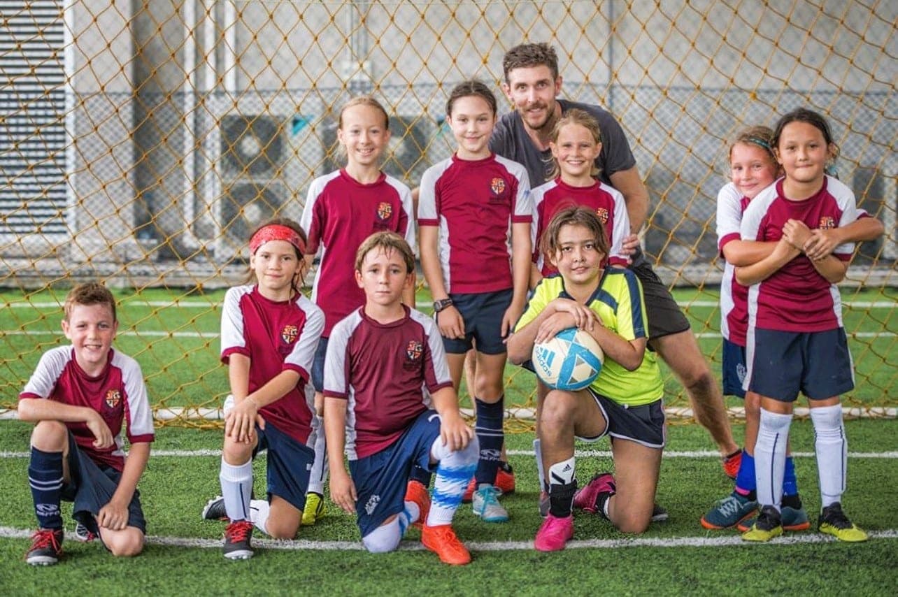 The club’s first group with their coach on the pitch, in the maroon and white kit of its early years