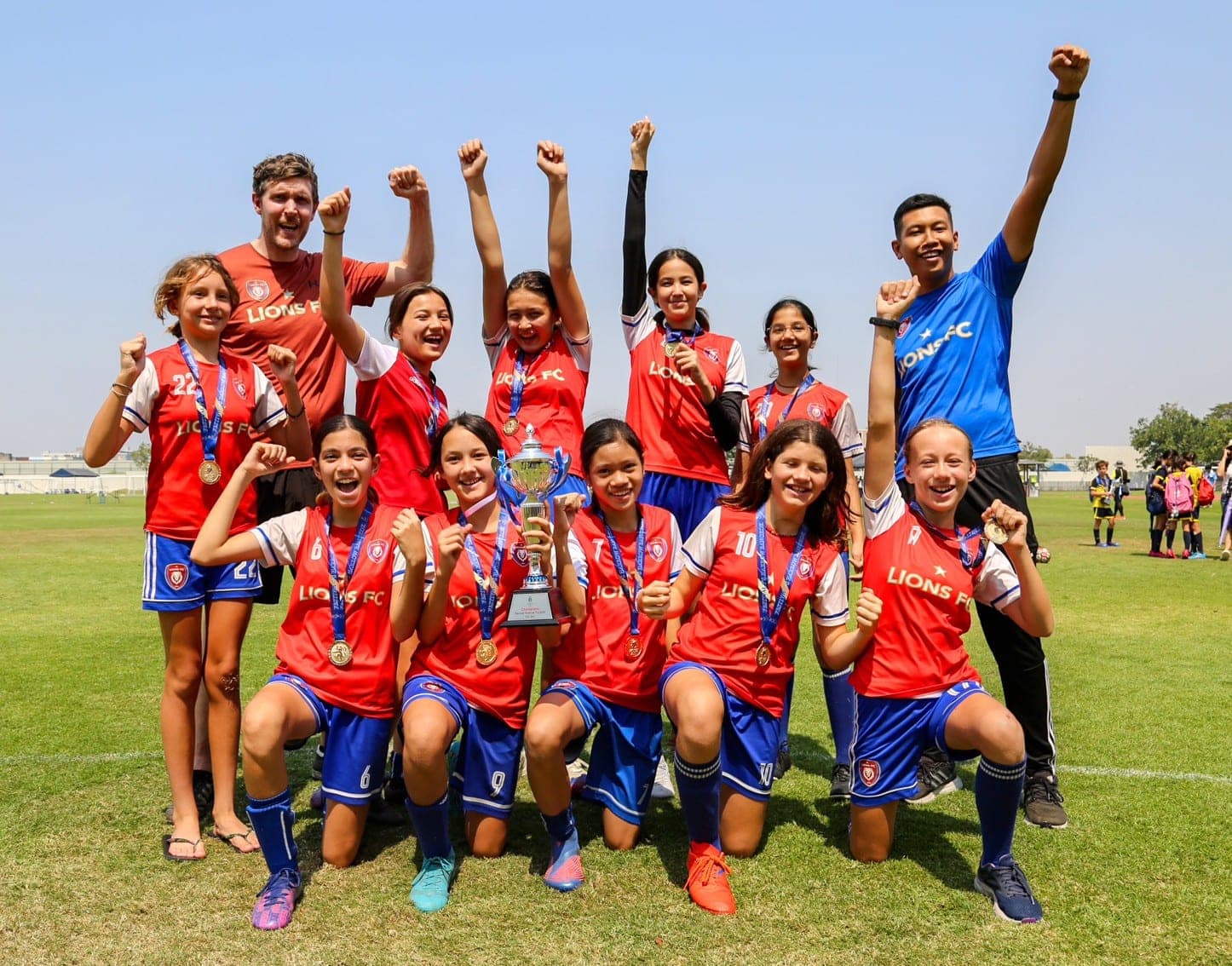 The squad celebrating with the cup, arms in the air, after winning a tournament