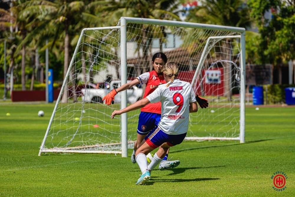 A player shooting at goal with a defender closing in