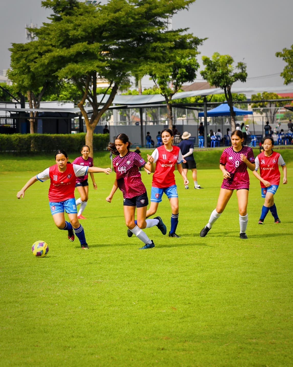 A match in progress on a grass pitch, players spread across the field