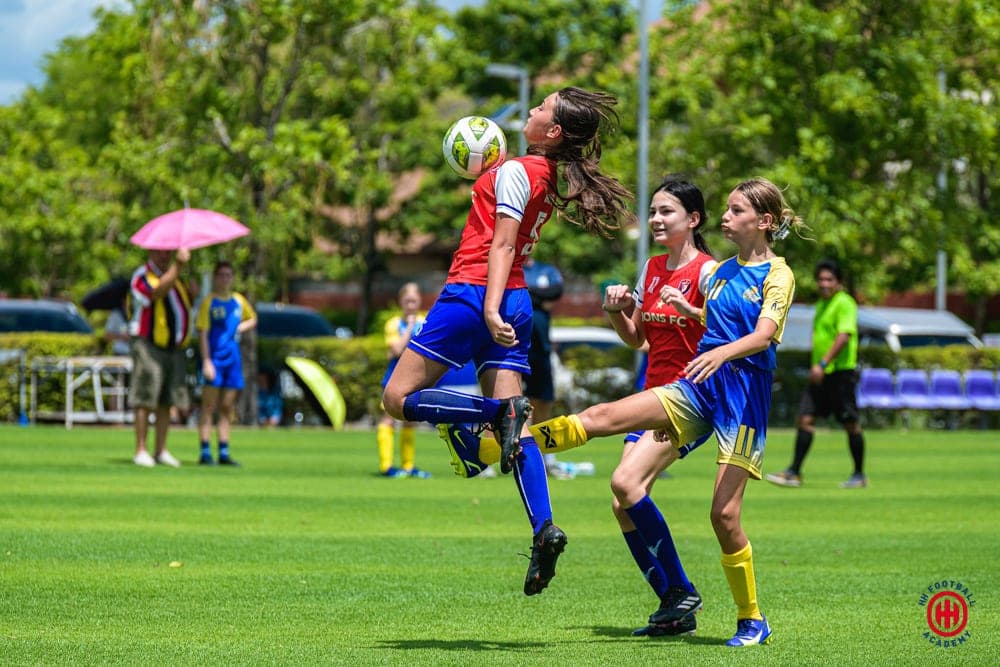 Two players rising together for a high ball during a match