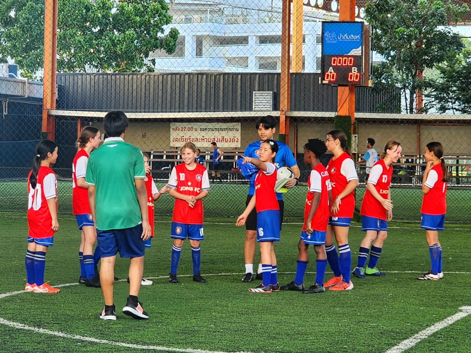 A coach talking the group through a drill on the covered pitch