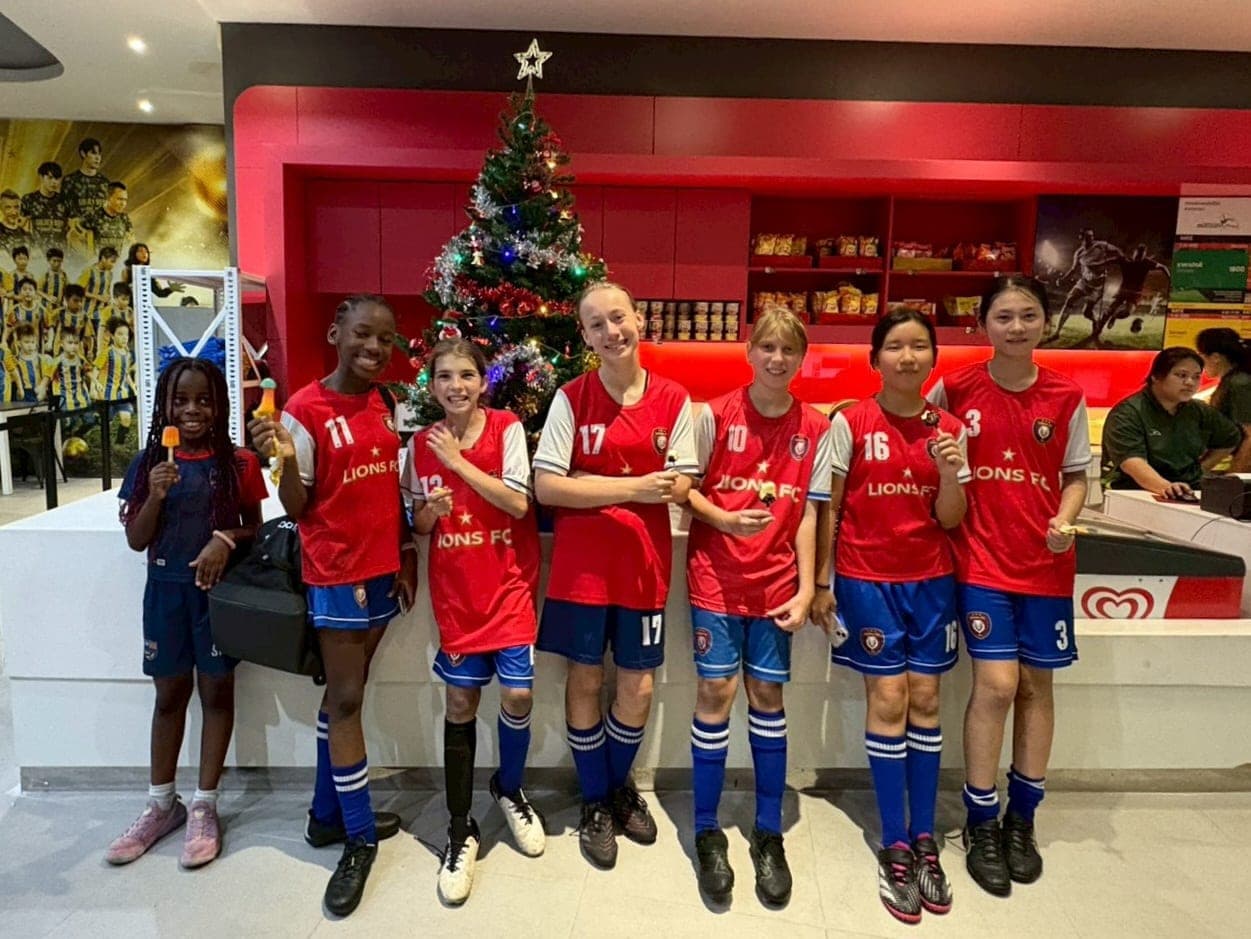 Players in club kit standing together beside a Christmas tree