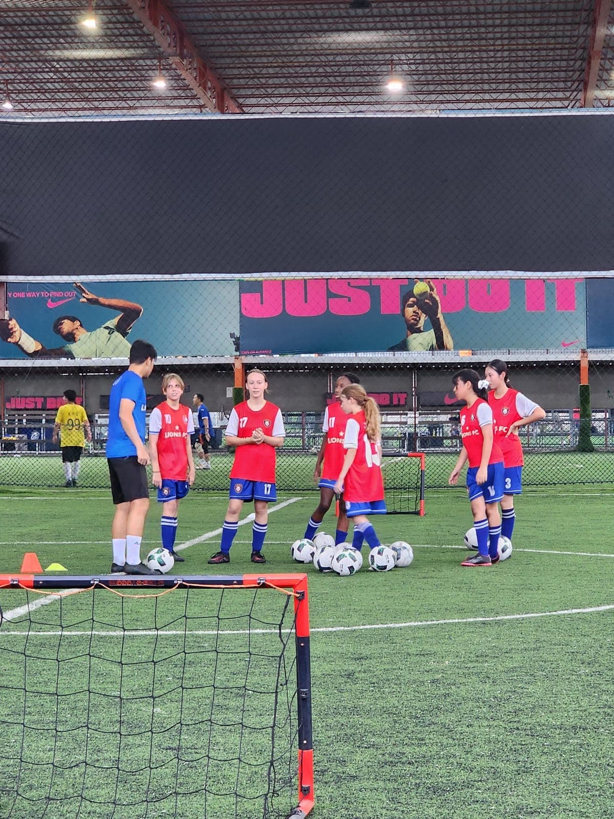 Players by a small goal on the covered pitch