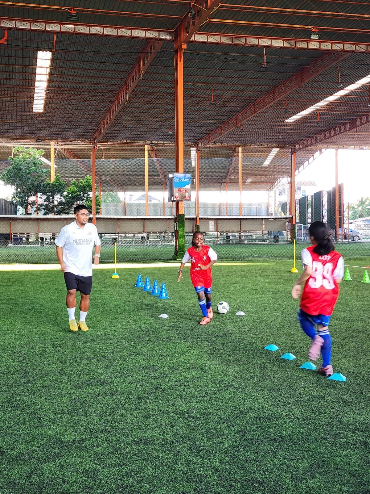 Players working with cones on the covered pitch