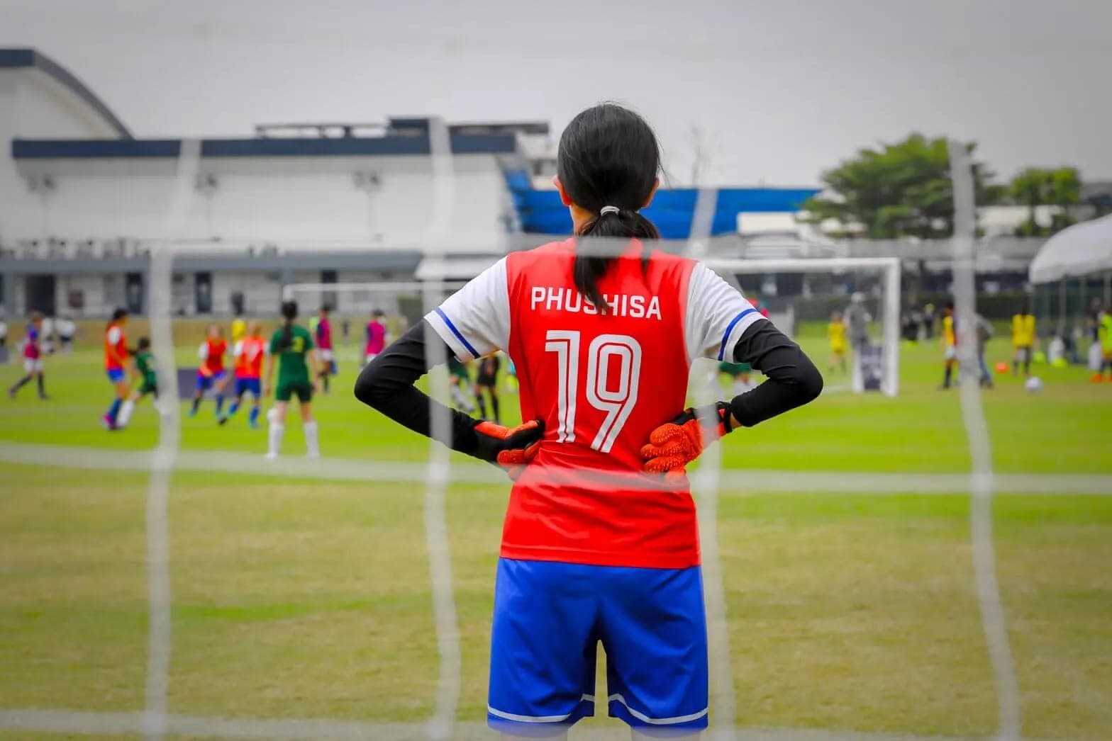 A Lions FC player watching the game from the edge of her penalty area