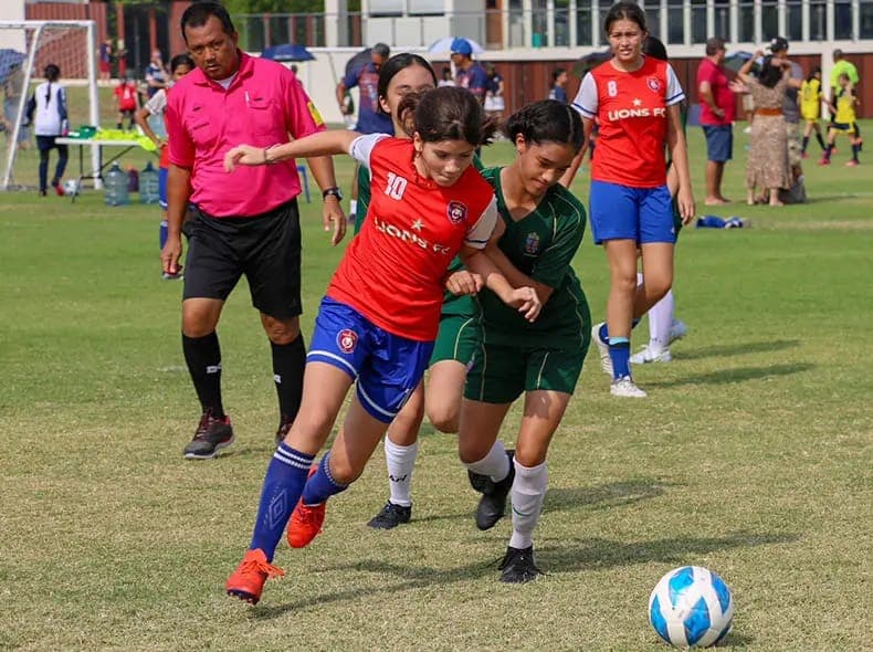 ผู้เล่นสองคนบังบอลกันอยู่ต่อหน้ากรรมการ